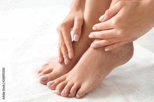 Woman with beautiful feet on white towel, closeup. Spa treatment