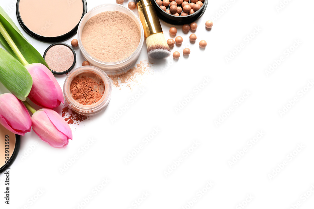 Many different makeup products and spring flowers on white background, top view Many different makeup products and spring flowers on white background, top view