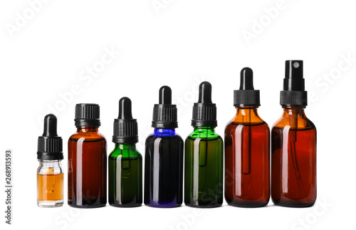 Cosmetic bottles of essential oils on white background
