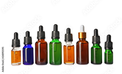 Cosmetic bottles of essential oils on white background