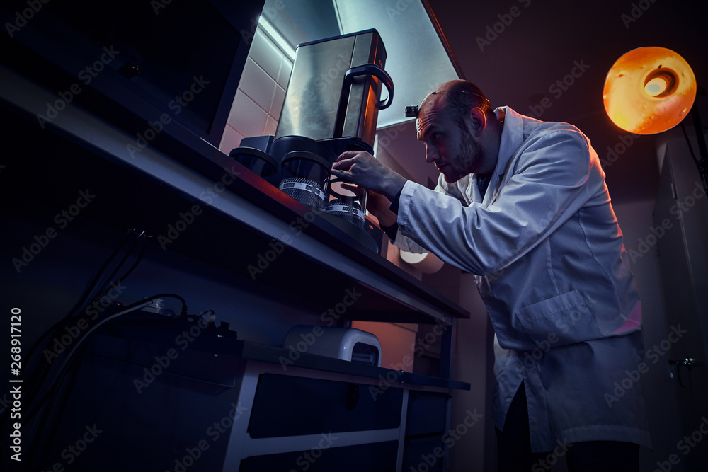 Focused watchmaker is working with autoclave at his own studio. Focused watchmaker is working with autoclave at his own studio.