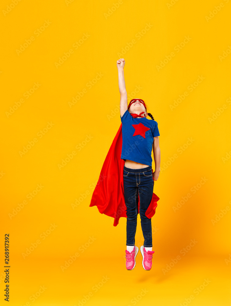 concept of child superhero costume on yellow background concept of child superhero costume on yellow background