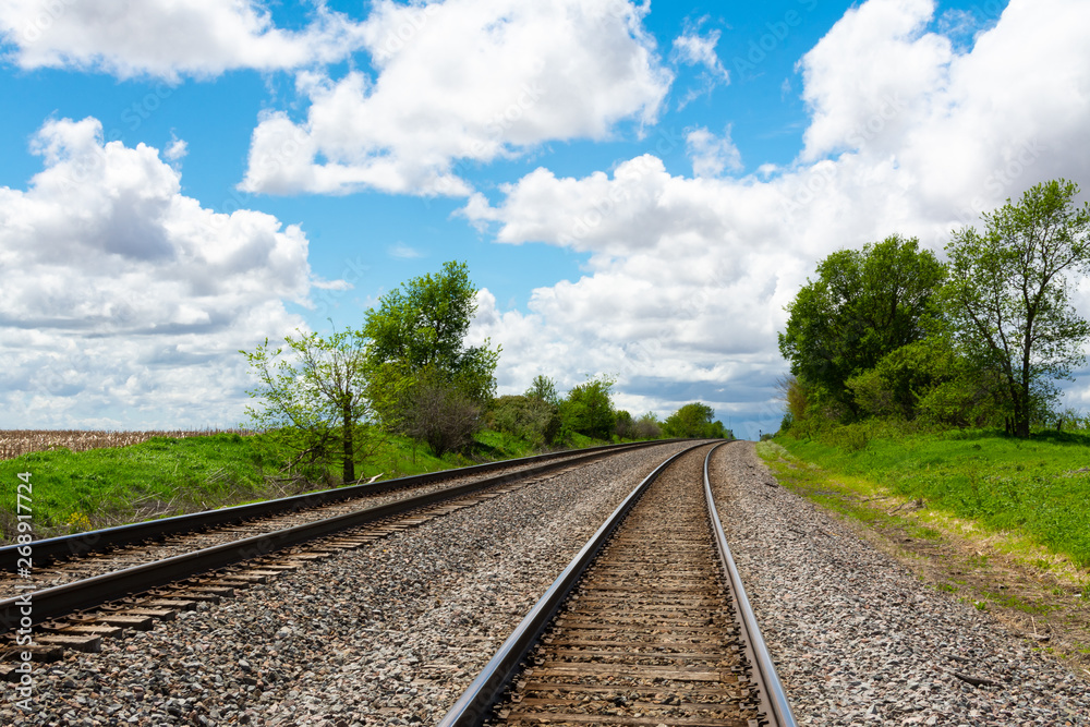 Fototapeta premium Train tracks through the Illinois countryside on a beautiful Spring afternoon.
