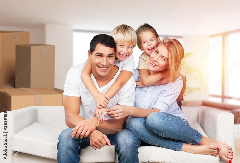 Beautiful smiling family sitting at sofa at home Beautiful smiling family sitting at sofa at home