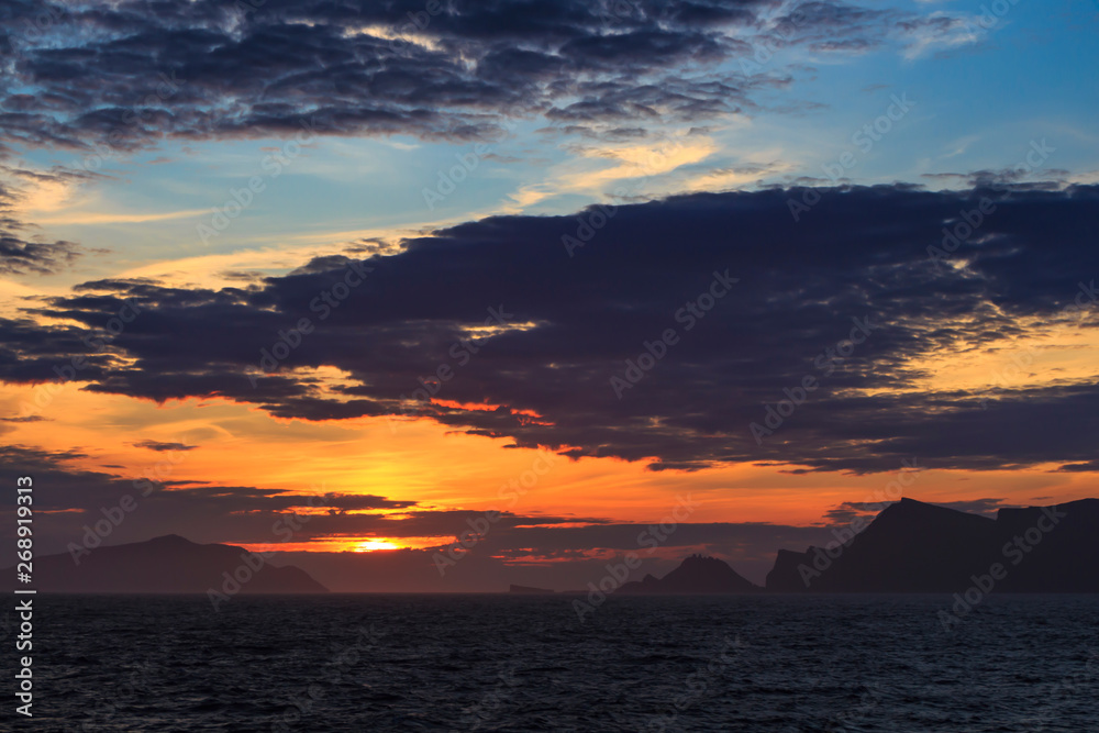sunrise on the ocean with rocky coastline
