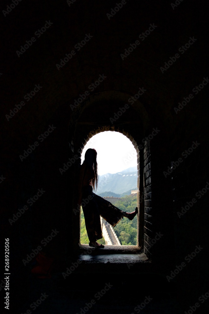 Silhouette of long haired lady in flares against Great Wall of China