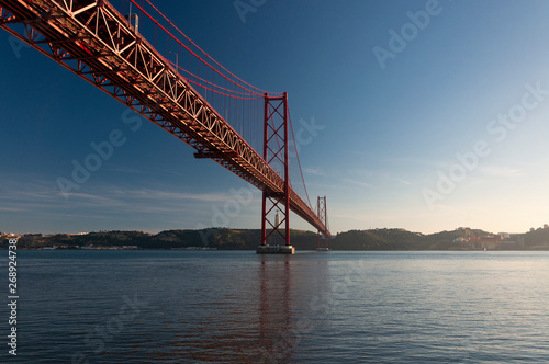 Scenic view of the 25 of April Bridge (Ponte 25 de Abril) over the Tagus River in the city of Lisbon, Portugal; Concept for travel in Portugal