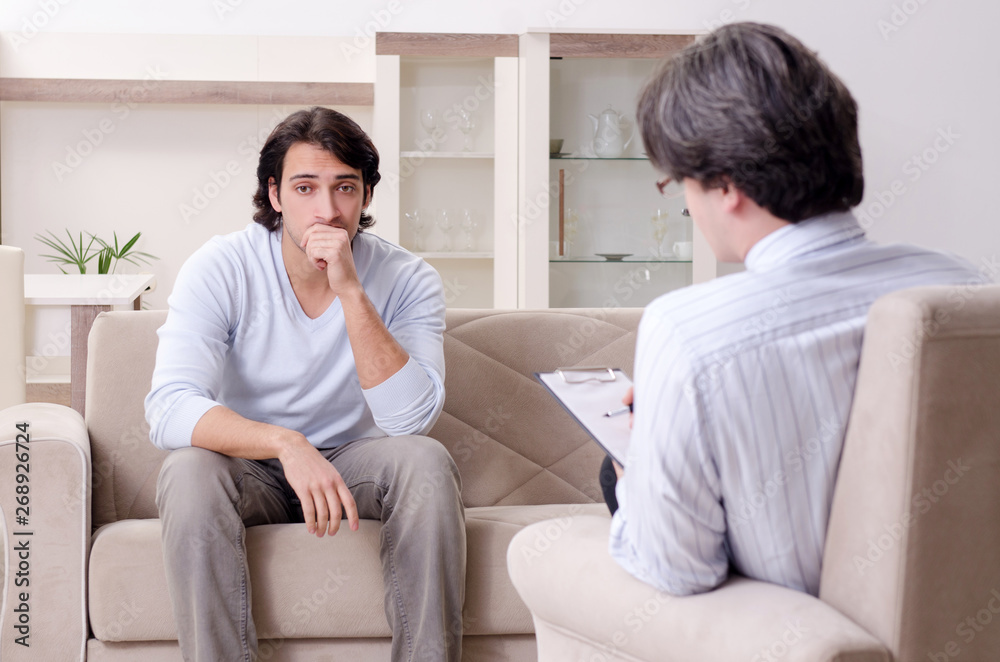 Young male patient discussing with psychologist personal problem