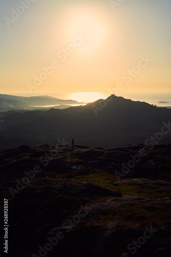 Silhouette of a person contemplating an enormous landscape from Mount Galiñeiro in Vigo, Spain