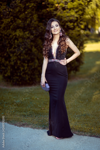 Beautiful young lady in luxury black dress is ready for her prom night