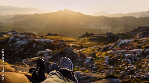 Panoramic detail of two pair of feet in front of a defocused landscape at sunset © Ruben Chase
