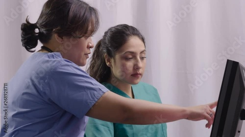 Medical team reading computer screen together