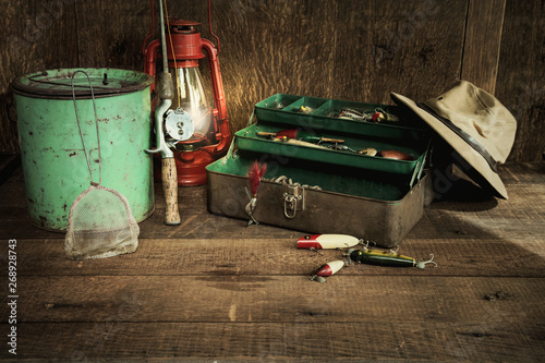 Vintage fishing equipment and lantern on grungy wood surface