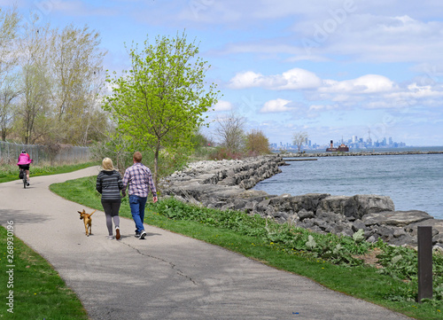 Quadro su tela A couple walks a dog as a cyclist rides by on Toronto's waterfront trail route b