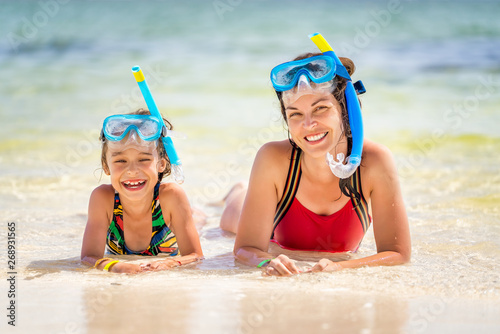 Young mother and little daughter in snorkeling masks enjoing the beach in Dominican Republic