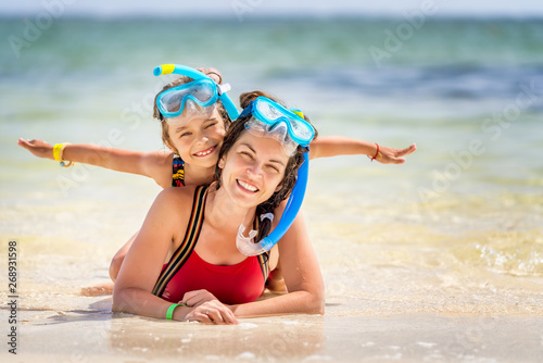 Young mother and little daughter in snorkeling masks enjoing the beach in Dominican Republic