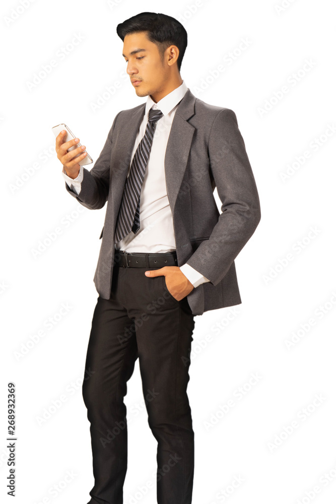 Happy young businessman standing with smartphone in suit on white background, isolated concept
