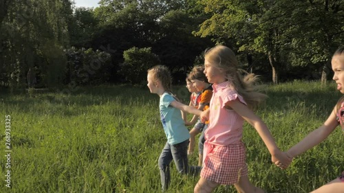 Many different kids running in the park on sunny summer day in casual clothes