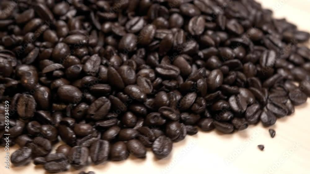 Fresh Organic Whole Coffee Beans on Turn Table Spinning Slowly Fresh Organic Whole Coffee Beans on Turn Table Spinning Slowly