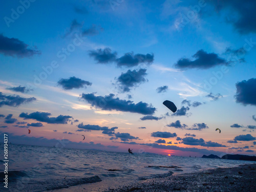 Silhouette people kitesurfing sunset clouds. Koh Phangan. Thailand