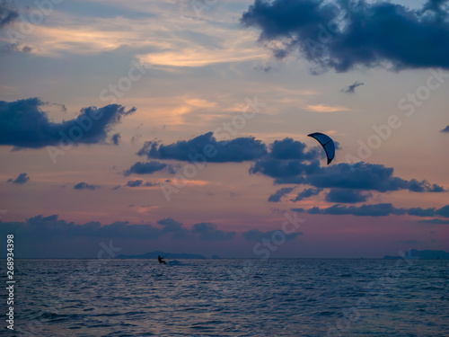 Silhouette people kitesurfing sunset clouds. Koh Phangan. Thailand