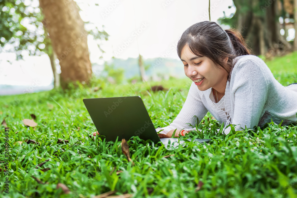 bueatiful woman with laptop on green grass in park bueatiful woman with laptop on green grass in park