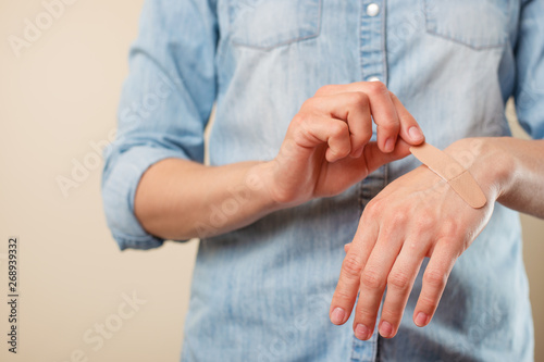 The girl holds and glues the patch on the hand, on the wound, treatment, throwing while smoking