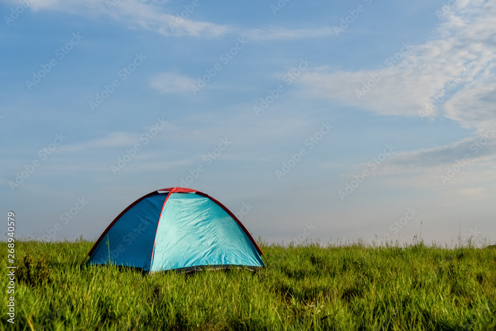 tent on grass field with blue sky background
