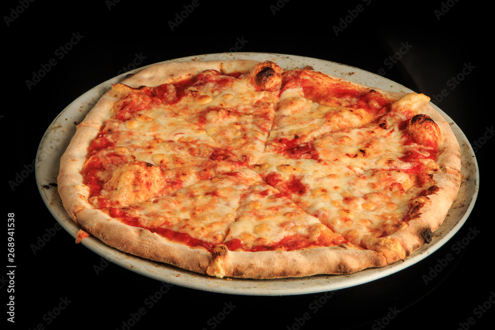 top view of whole sliced cheese pizza on round white plate