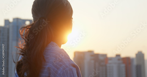 Photography Woman look at the building in city and thinking under sunset