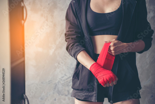Boxing Woman prepare to trianing session and kickboxing,workout at thai boxing gym.Fit Female exercise hard to strengther muscle.Healthy concept.