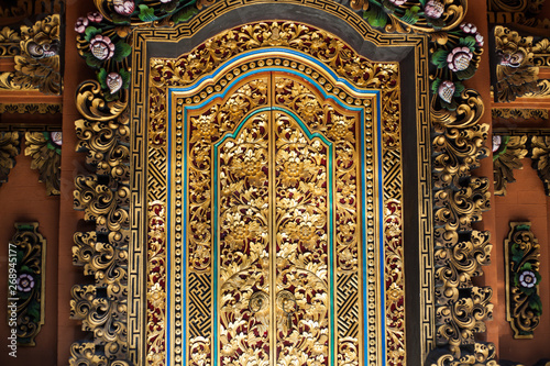 fragment of a wooden door decorated with gold in Balinese style