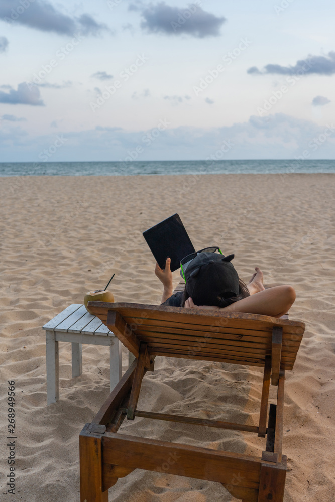 Vertical photo of young girl use tablet on the beach