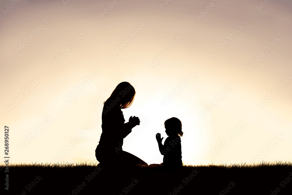 Mother Praying with her Young Child Outside at Sunset. Mother Praying with her Young Child Outside at Sunset.
