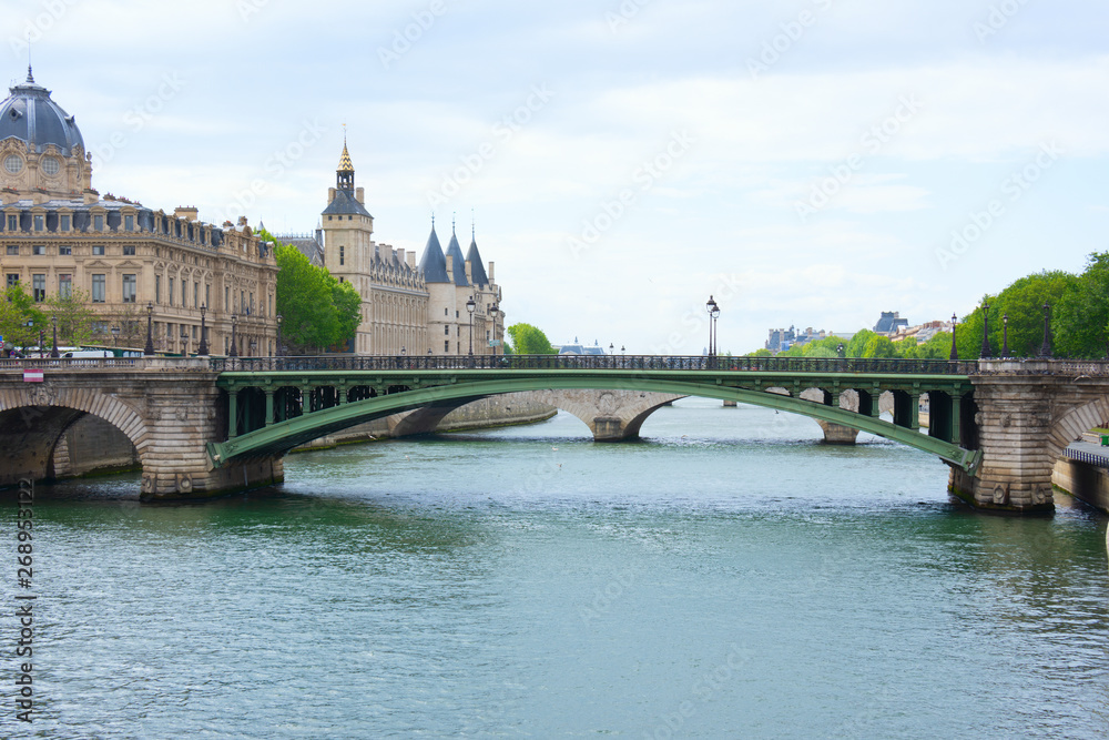 Notre Dame Bridge over the beautiful River Seine in Paris, France, with Bailiffs-Audienciers of the Commercial Court of the Seine and Conciergerie along the shoreline.