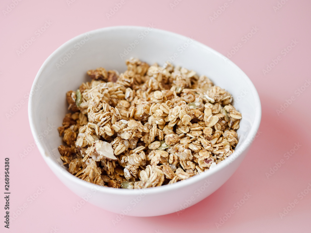 Cereal corn flake whole grains in white bowl on pink background. Cereal corn flake whole grains in white bowl on pink background.