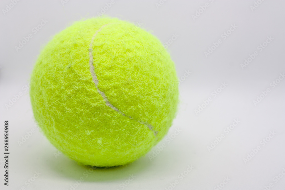 Yellow tennis ball closeup on a white background.