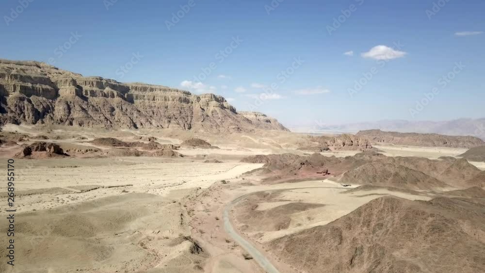 Long stretch of an old Desert road with mountains and blue sky in the background, Aerial footage. Long stretch of an old Desert road with mountains and blue sky in the background, Aerial footage.
