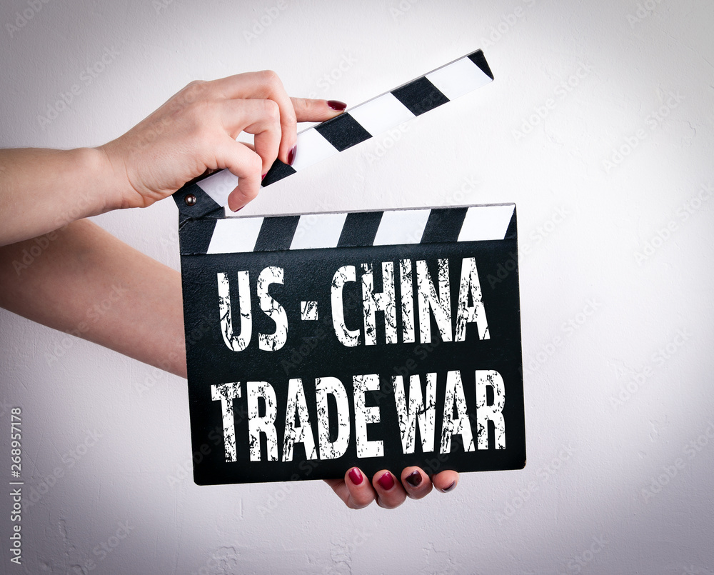 US - China trade war. Female hands holding movie clapper