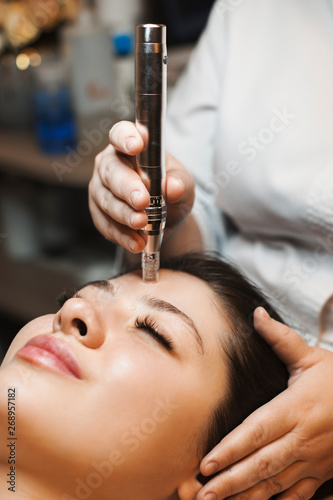 Canvastavla Hand of a female cosmetician doing a microdermabrasion non invasive procedures on a female face in a cosmetologist salon