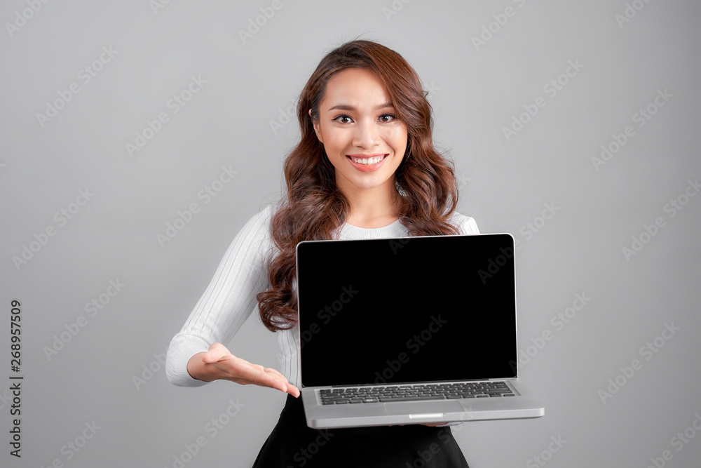 Businesswoman Presenting Laptop. Isolated On gray Background Businesswoman Presenting Laptop. Isolated On gray Background