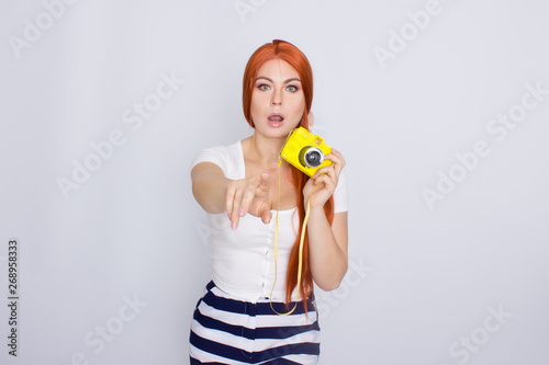 Redhair woman using yellow photo camera
