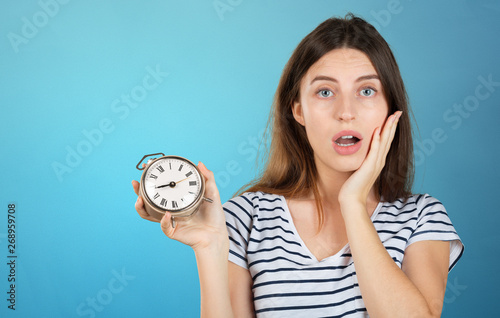 Happy business woman holding a clock isolated