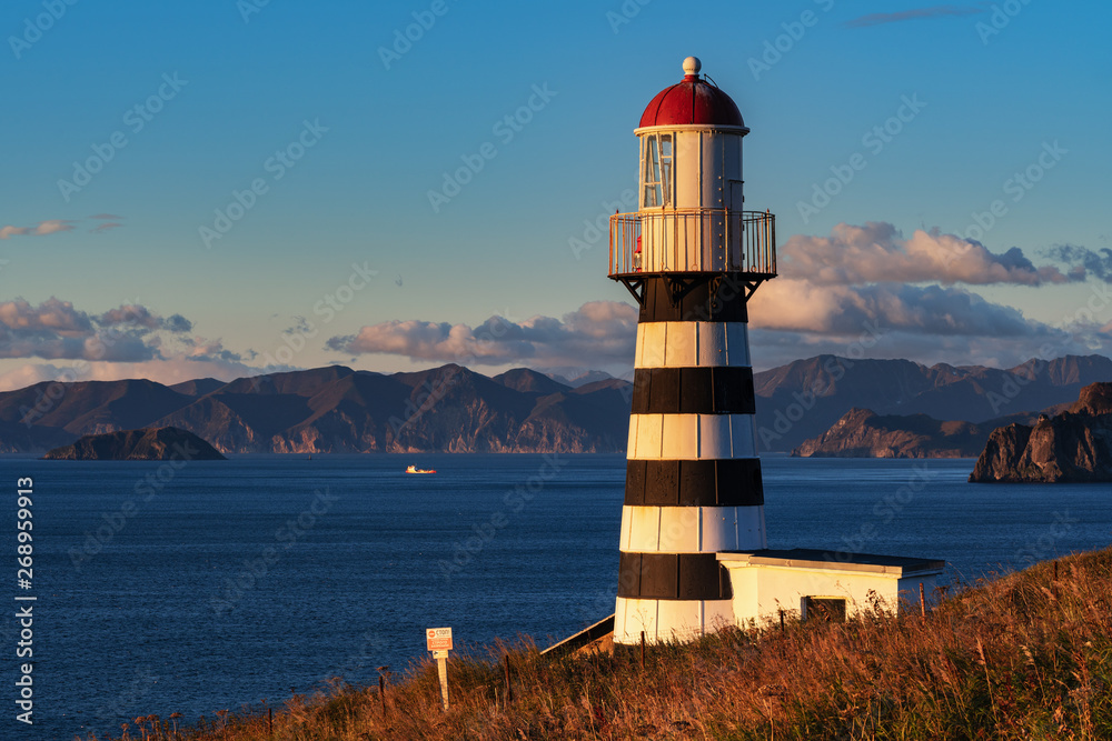 Petropavlovsky Lighthouse (founded in 1850) located on Kamchatka Peninsula on shore of Avacha Gulf in Pacific Ocean, vicinity of Petropavlovsk-Kamchatsky City. View of lighthouse in morning at sunrise