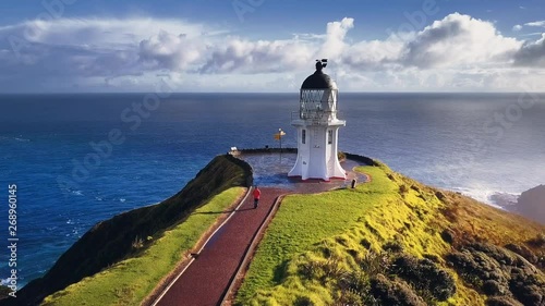 Aerial footage of lone tourist walking to Cape Reinga lighthouse, the northernmost point of New Zealand and popular tourist attraction.
