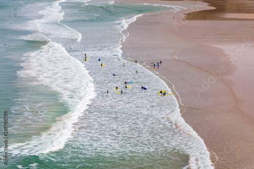 Surfers in the waves off Mawgan Porth Beach, Cornwall, UK photo