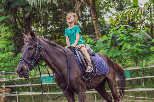 Boy horseback riding, performing exercises on horseback © galitskaya