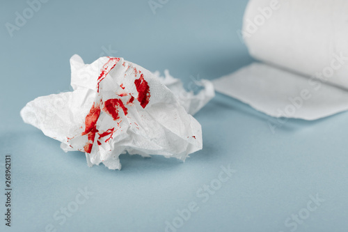 Blood on tissue paper on white background. Health medical concept. photo