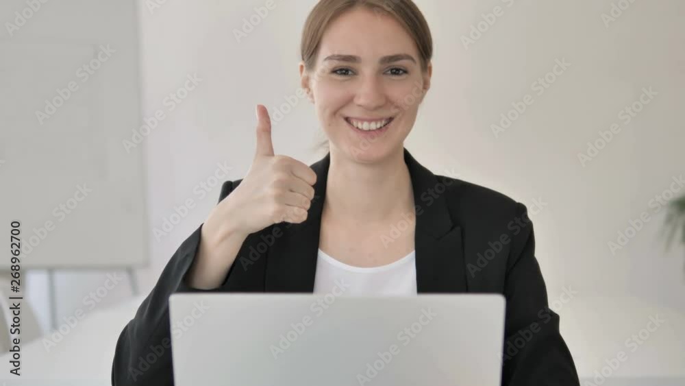 Thumbs Up by Young Businesswoman at Work Thumbs Up by Young Businesswoman at Work