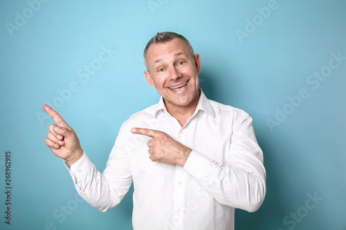 Happy middle-aged man point...